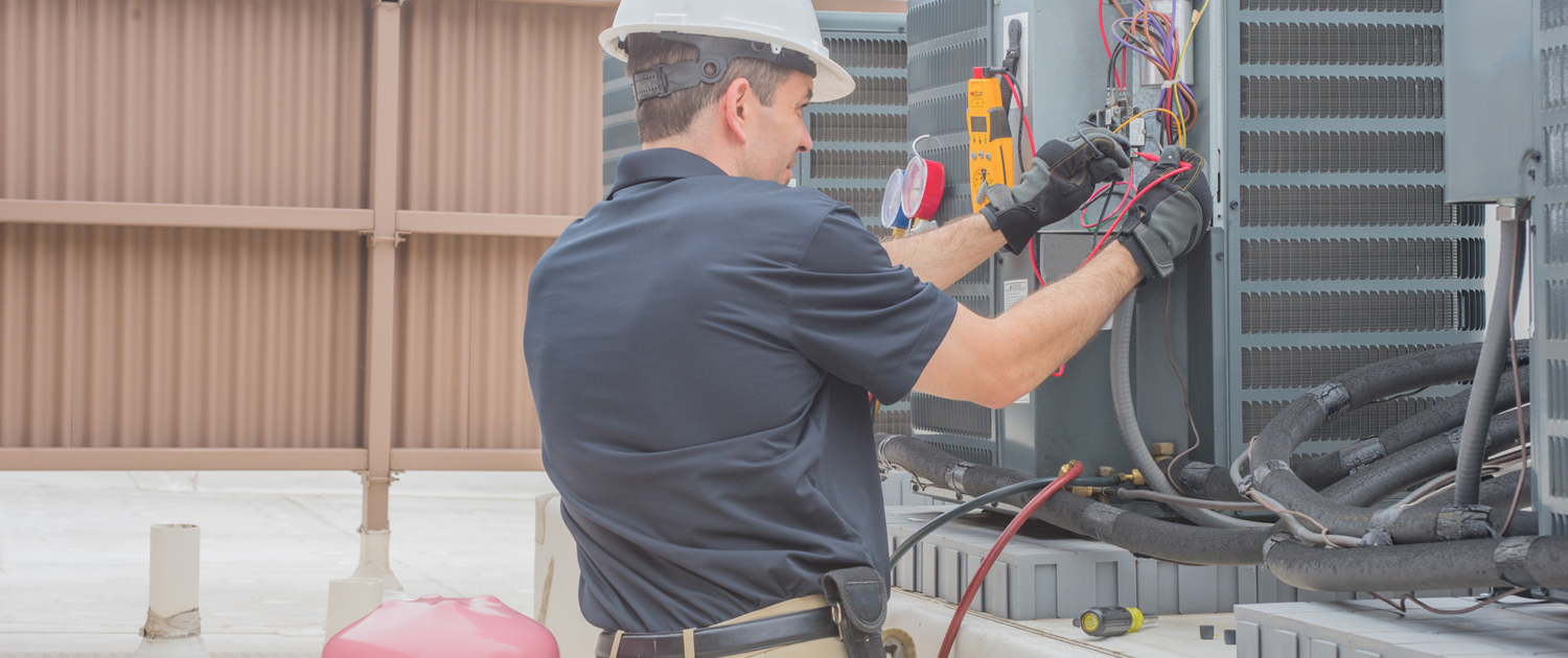 Worker Repairing Hvac Unit On Roof